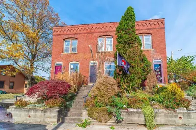 a red brick building with a flag in front of it at Cozy Brick-Short North Condo - (fenced yard) - OSU in Columbus