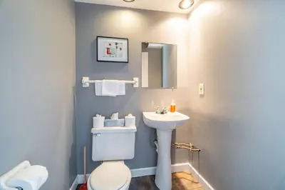 a bathroom with a white toilet and a sink at Cozy Brick-Short North Condo - (fenced yard) - OSU in Columbus