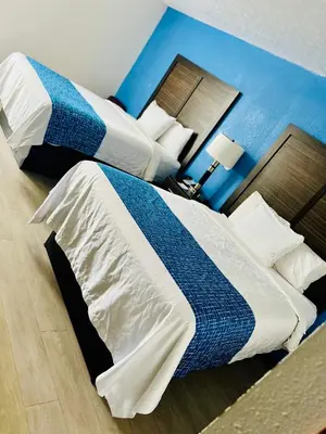 a hotel room with two beds and a blue wall at Travelodge by Wyndham Gallipolis in Gallipolis