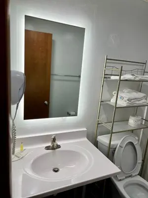 a bathroom with a sink and a mirror and a toilet at Travelodge by Wyndham Gallipolis in Gallipolis