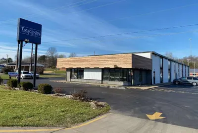 a building with a sign in a parking lot at Travelodge by Wyndham Gallipolis in Gallipolis