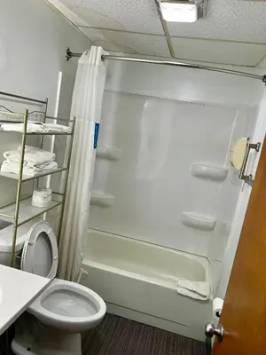 a bathroom with a shower and a toilet at Travelodge by Wyndham Gallipolis in Gallipolis
