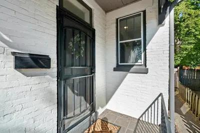 a black door on a white brick house at Perfect location-Short North home HUGE4-car garage in Columbus