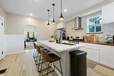 a kitchen with a sink and a counter with stools at Perfect location-Short North home HUGE4-car garage in Columbus