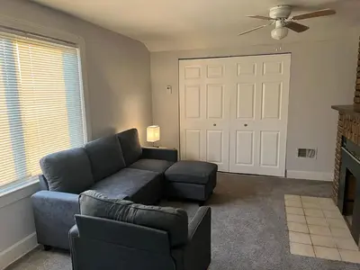 a living room with a blue couch and a fan at Cleveland Airport - 2nd Floor - WonDos Apartment in Cleveland