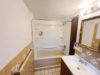 a bathroom with a tub and a sink and a mirror at Cleveland Airport - 2nd Floor - WonDos Apartment in Cleveland