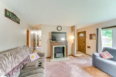 a living room with a couch and a fireplace at 8 Mi to Cleveland Family Home with Fenced Backyard! in Brooklyn