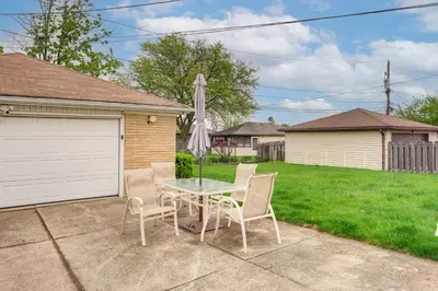 a patio with a table and chairs and an umbrella at 8 Mi to Cleveland Family Home with Fenced Backyard! in Brooklyn