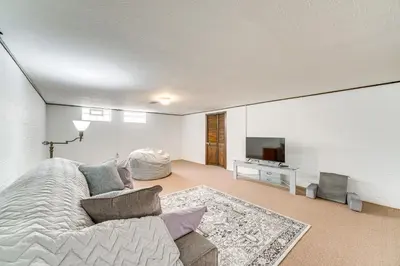a white room with a bed and a television at 8 Mi to Cleveland Family Home with Fenced Backyard! in Brooklyn