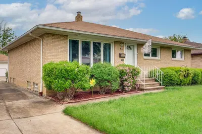 a brown brick house with bushes and trees at 8 Mi to Cleveland Family Home with Fenced Backyard! in Brooklyn