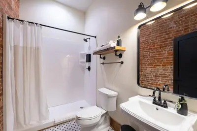 a bathroom with a white toilet and a sink at Courthouse Suite - Room 1 in Versailles