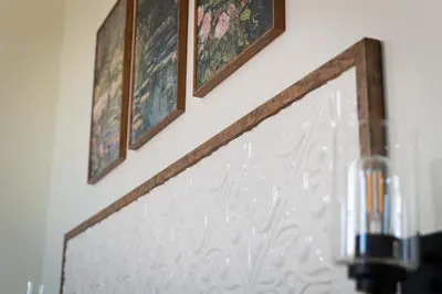 two framed pictures on a wall above a fireplace at Courthouse Suite - Room 1 in Versailles