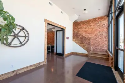 an open hallway with a brick wall and a staircase at Courthouse Suite - Room 1 in Versailles