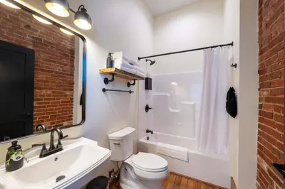 a bathroom with a white toilet and a sink at Courtyard Queen - Room 2 in Versailles