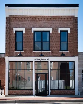 a brick building with glass doors on a street at Courtyard Queen - Room 2 in Versailles