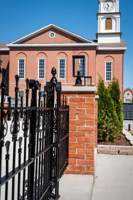 a black fence in front of a building with a clock tower at Courtyard Queen - Room 2 in Versailles