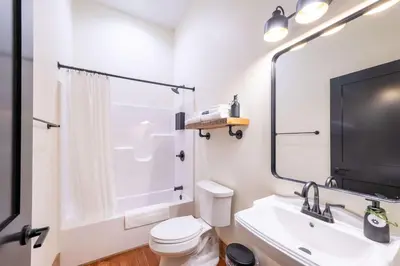 a bathroom with a toilet and a sink and a tv at Courtyard King - Room 3 in Versailles
