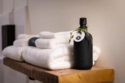 a bottle of wine sitting on a pile of towels at Courtyard King - Room 3 in Versailles