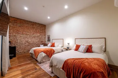 a bedroom with two beds and a brick wall at Cozy Corner - Room 5 in Versailles