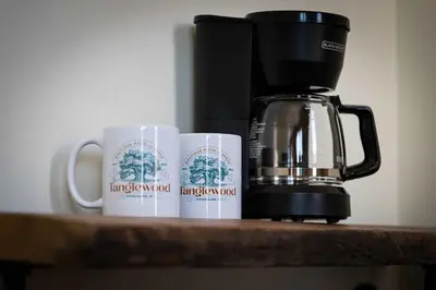 two coffee mugs on a counter next to a coffee maker at Cozy Corner - Room 5 in Versailles
