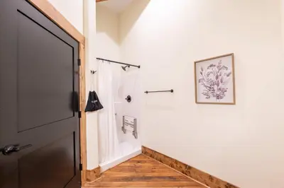 a bathroom with a shower and a door at ADA Suite - Room 6 in Versailles