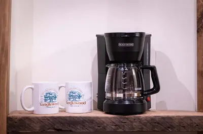 a coffee maker sitting on a shelf with two mugs at ADA Suite - Room 6 in Versailles