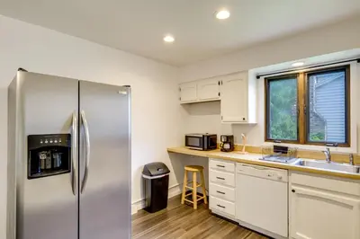 a kitchen with white cabinets and a stainless steel refrigerator at 1 Mi to Freer Field Ashland Home with Yard! in Ashland