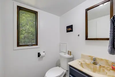 a bathroom with a sink and a toilet and a mirror at 1 Mi to Freer Field Ashland Home with Yard! in Ashland