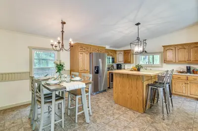 a kitchen with a table and a refrigerator at Walk to River Loudonville Retreat with Hot Tub! in Loudonville