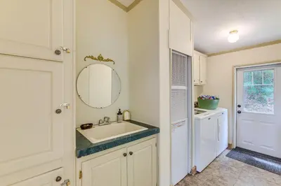 a white bathroom with a sink and a mirror at Walk to River Loudonville Retreat with Hot Tub! in Loudonville
