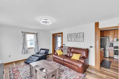 a living room with a leather couch and a table at Cozy Getaway with Hot Tub, Patio & Fenced Yard home in Garfield Heights