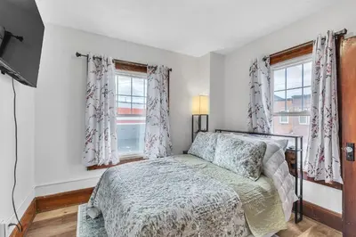 a bedroom with a bed and two windows at Cozy Getaway with Hot Tub, Patio & Fenced Yard home in Garfield Heights