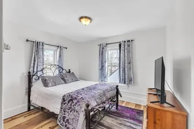 a bedroom with a bed and a flat screen tv at Cozy Getaway with Hot Tub, Patio & Fenced Yard home in Garfield Heights