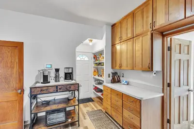 a kitchen with wooden cabinets and a refrigerator at Cozy Getaway with Hot Tub, Patio & Fenced Yard home in Garfield Heights