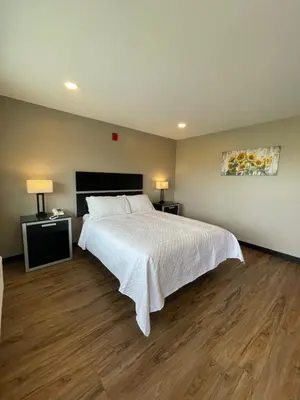 a bedroom with a large bed and wooden floors at Four Seasons Inn in Gallipolis