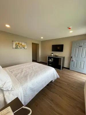 a bedroom with a white bed and a flat screen tv at Four Seasons Inn in Gallipolis