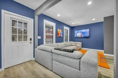 a living room with a couch and blue walls at Tremont Jewel Group Stay in the Heart of Tremont in Cleveland
