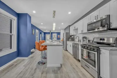 a large kitchen with blue walls and a counter top at Tremont Jewel Group Stay in the Heart of Tremont in Cleveland