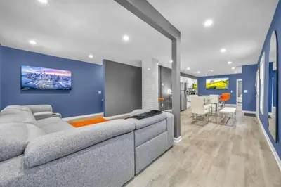 a living room with a couch and a blue wall at Tremont Jewel Group Stay in the Heart of Tremont in Cleveland