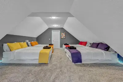 a attic room with two beds with colorful pillows at Tremont Jewel Group Stay in the Heart of Tremont in Cleveland