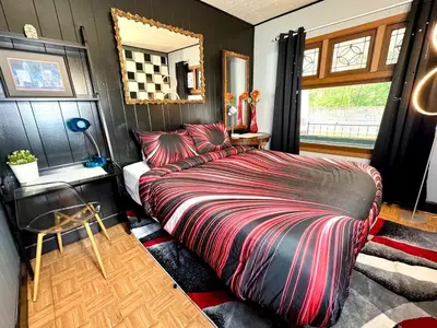 a bedroom with a bed and a table and a mirror at Sleep with a Lion!! 6 bedroom house, near downtown, Ohio city Tremont! in Cleveland