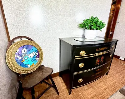 a chair next to a dresser with a potted plant at Sleep with a Lion!! 6 bedroom house, near downtown, Ohio city Tremont! in Cleveland