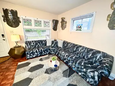 a black leather couch in a living room at Sleep with a LION! 3 bedroom, near Downtown, Tremont, Ohio city!! in Cleveland