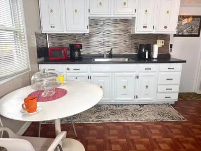 a kitchen with white cabinets and a white table at Sleep with a LION! 3 bedroom, near Downtown, Tremont, Ohio city!! in Cleveland