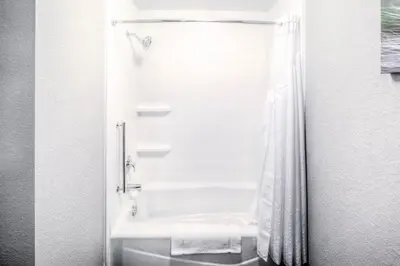 a bathroom with a tub and a shower with a sink at Holiday Inn Express & Suites Cleveland/Westlake by IHG in Westlake