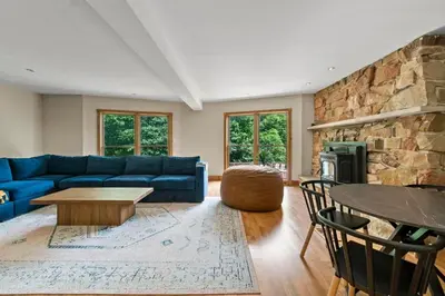 a living room with a blue couch and a stone wall at The Billy Lodge in Lucas