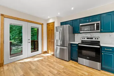 a kitchen with blue cabinets and stainless steel appliances at The Billy Lodge in Lucas