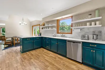 a large kitchen with blue cabinets and a table at The Billy Lodge in Lucas