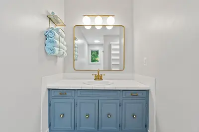 a bathroom with a blue sink and a mirror at The Billy Lodge in Lucas