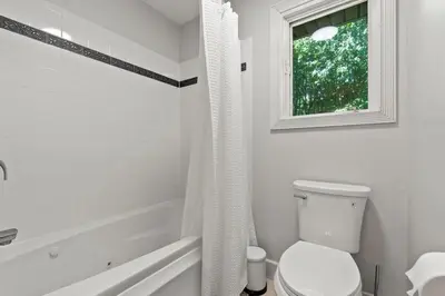 a white bathroom with a toilet and a window at The Billy Lodge in Lucas